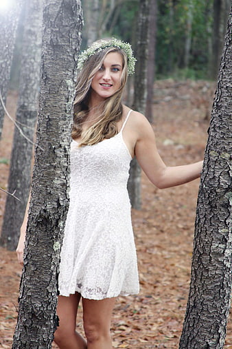 Blonde Woman in White Lace Dress and Flower Crown in Forest