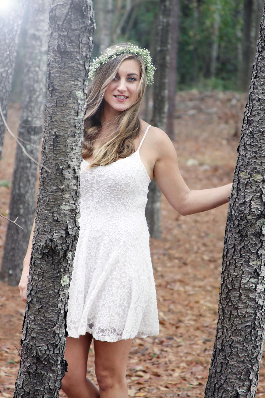 Blonde Woman in White Lace Dress and Flower Crown in Forest