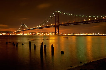 Night view of 25 de Abril Bridge in Lisbon with city lights