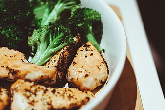 Close-up of grilled chicken and broccoli in a white bowl