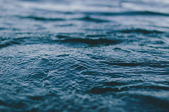 Close-up of rippling blue water surface with film grain texture