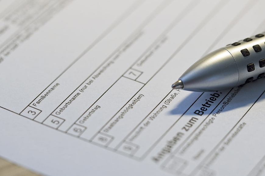 Close-up of silver pen on German business application form