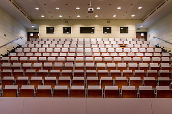 Empty university lecture hall with rows of wooden seats