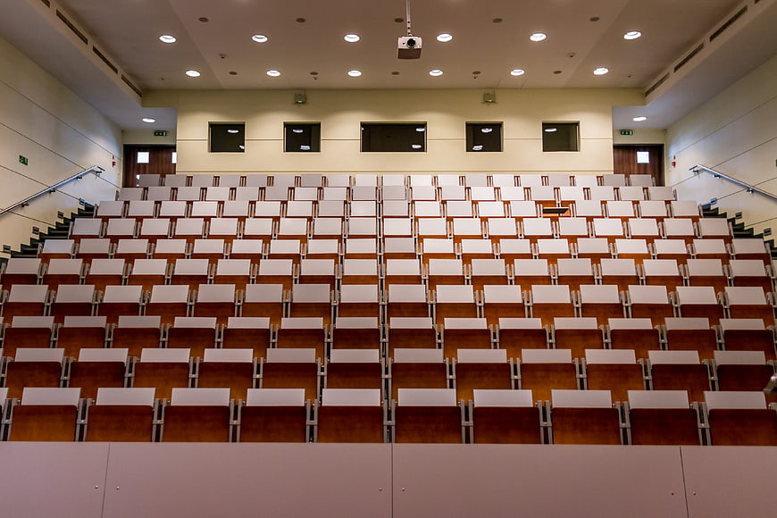 Empty university lecture hall with rows of wooden seats