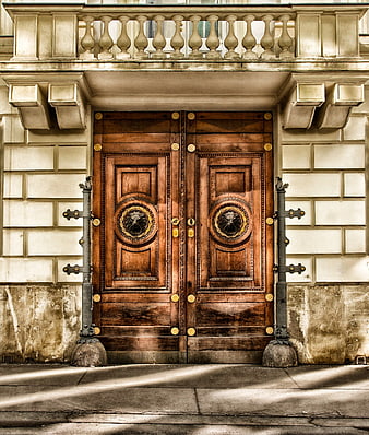 Ornate wooden double doors with lion head knockers on historic building facade