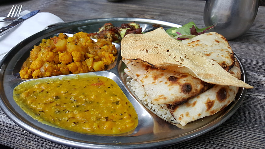 Traditional Indian Thali Meal with Curry, Rice, and Naan