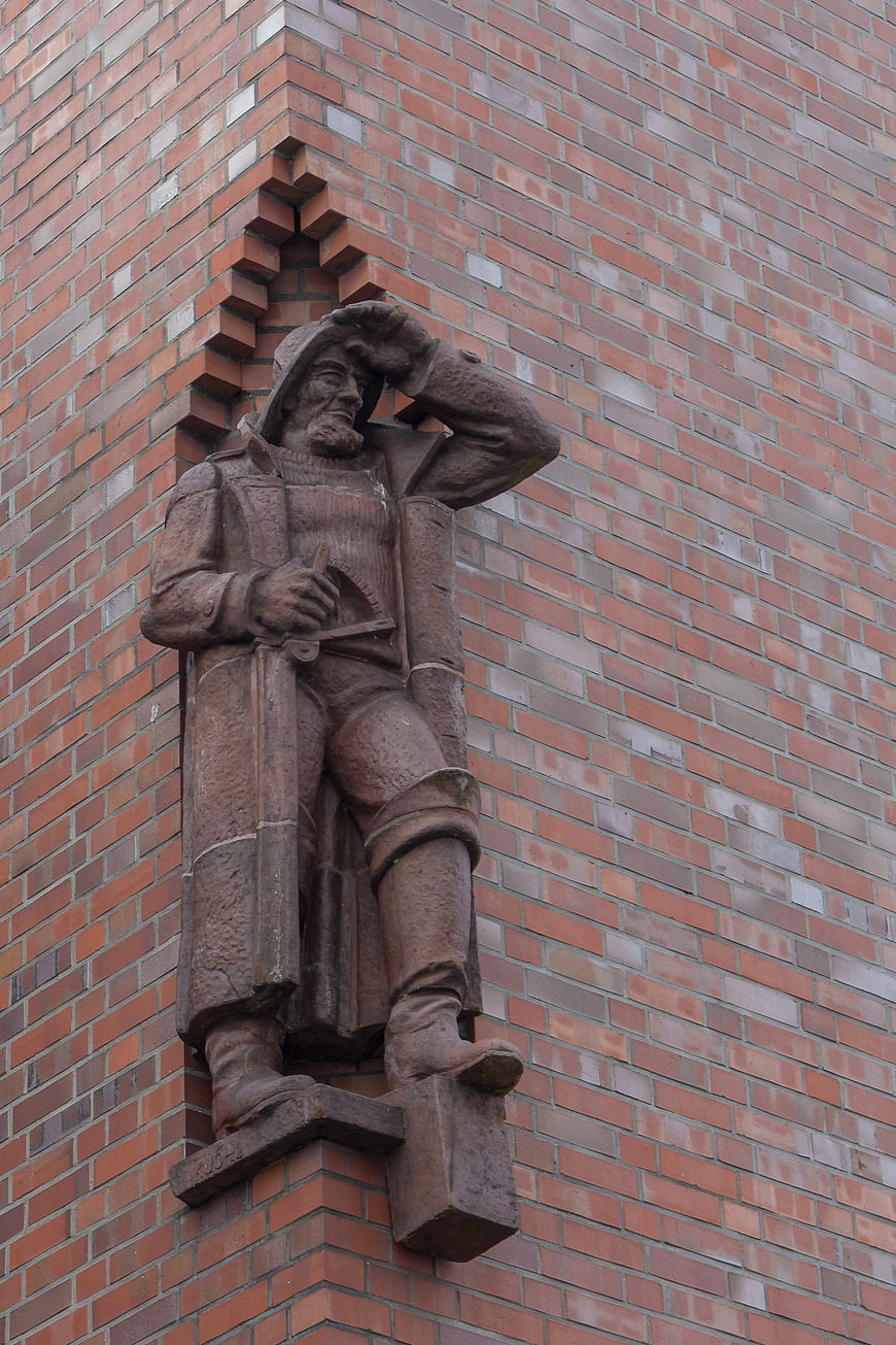 Stone Sculpture of Historical Figure on Brick Wall