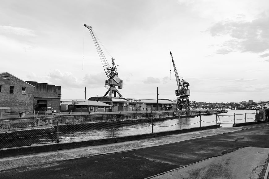 Black and white industrial harbor with cranes and dock