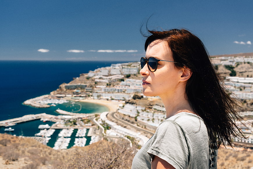 Woman in sunglasses overlooking coastal resort town