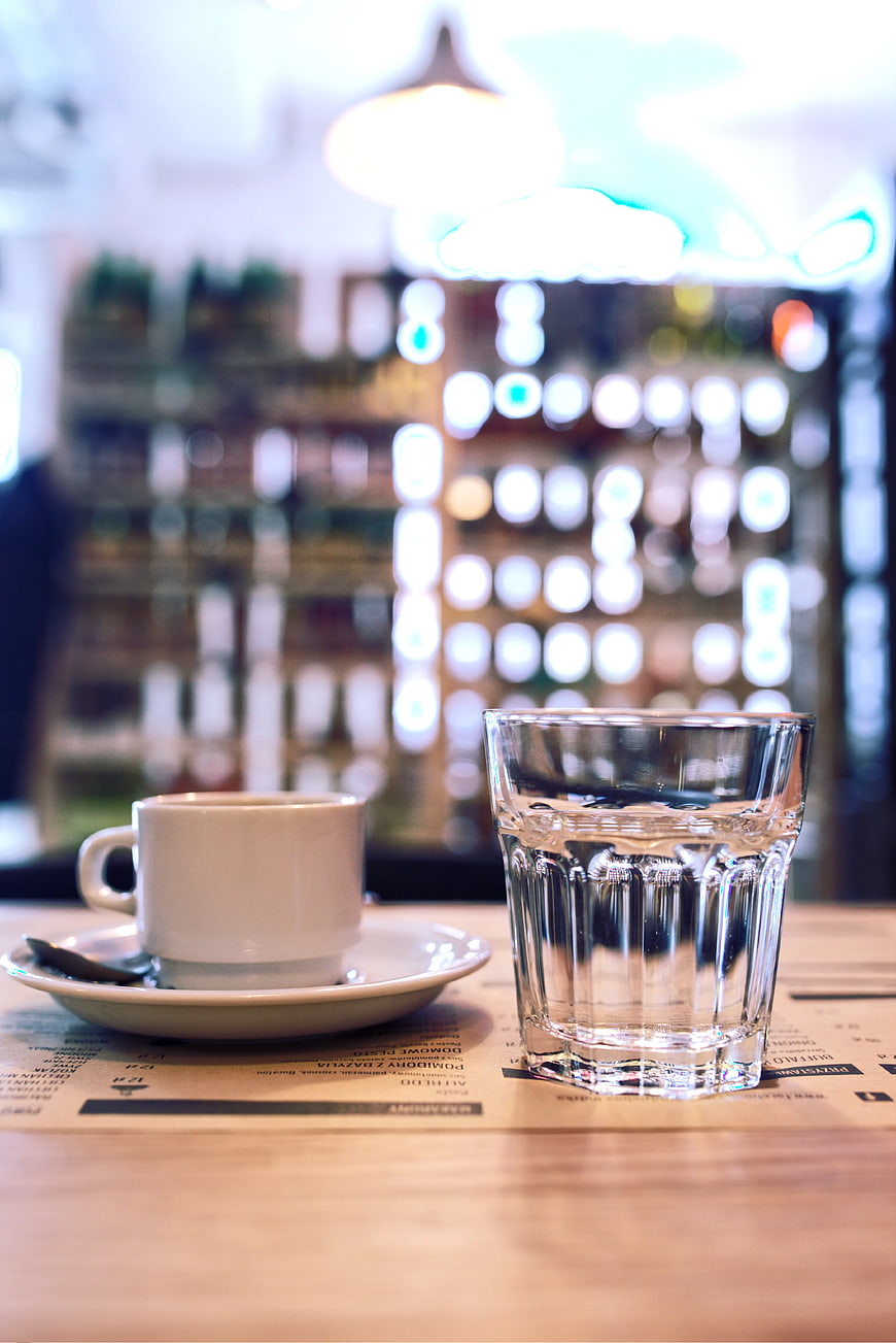 Coffee cup and water glass on cafe table