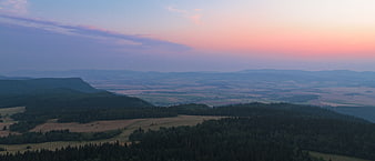 Aerial View of Rolling Hills and Forest at Sunset