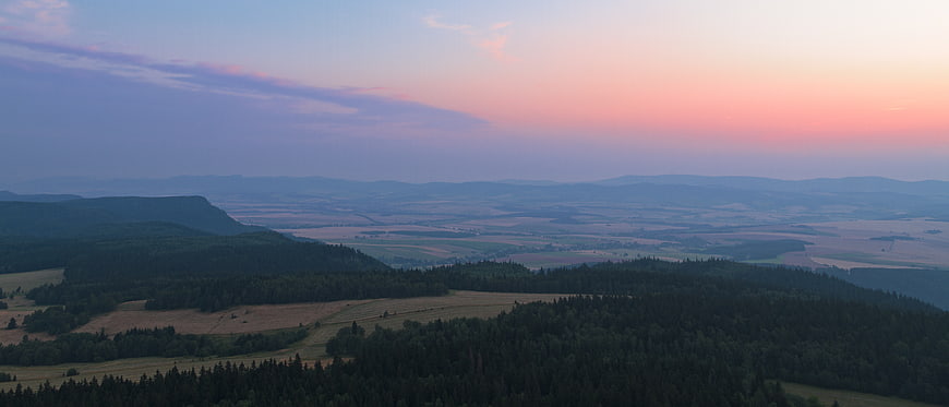 Aerial View of Rolling Hills and Forest at Sunset