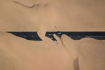 Aerial View of Sand Covered Desert Road with Car