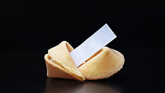 Broken Fortune Cookie with Blank Paper Strip on Black Background