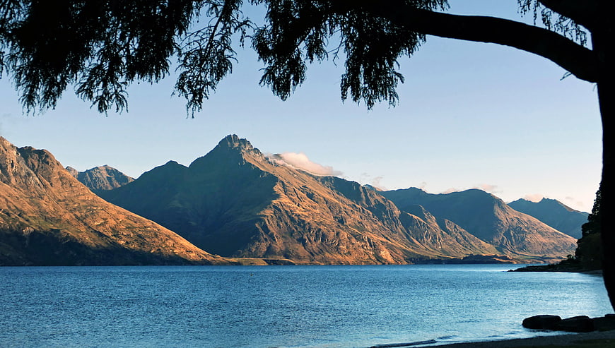 Scenic Mountain Lake View Framed by Tree Branches