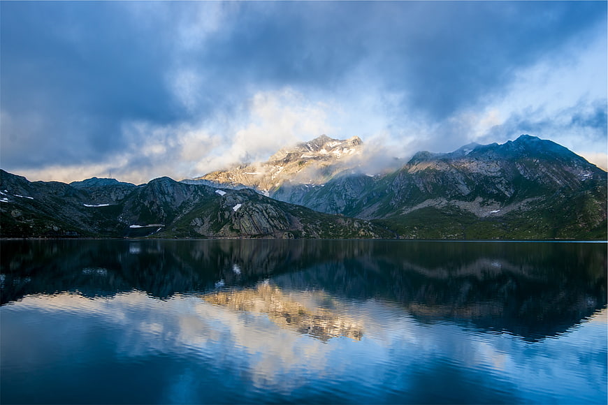 Serene Mountain Lake Reflection with Dramatic Clouds