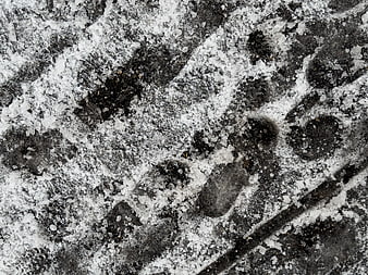Close-up of tire tracks in icy snow on asphalt