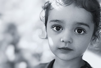 Black and white close-up portrait of a young girl with curly hair