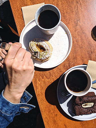 Top view of coffee and pistachio dessert on wooden table