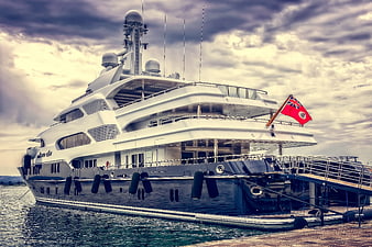 Luxury Yacht Docked at Port Under Dramatic Sky
