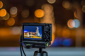 Sony camera on tripod with city bokeh background