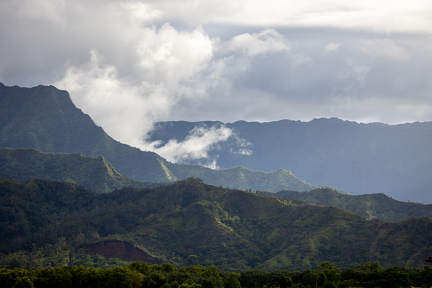 Lush Green Mountain Ranges with Clouds and Mist