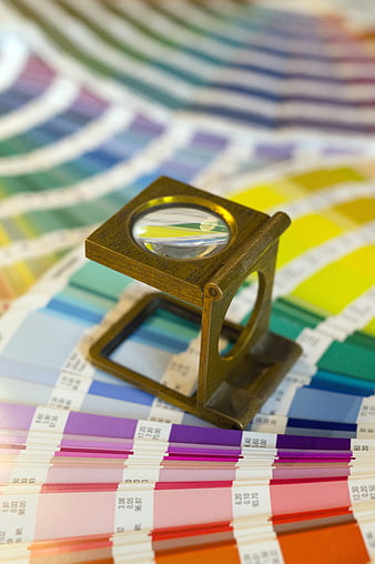 Magnifying glass on colorful Pantone color swatch chart