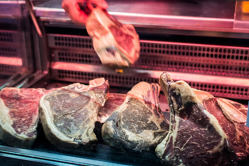 Fresh raw beef steaks in butcher shop display case