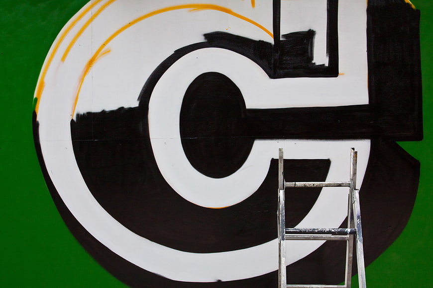 Close-up of large black and white graffiti letter on green wall