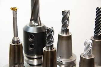 Assortment of CNC milling cutters and drill bits on white background