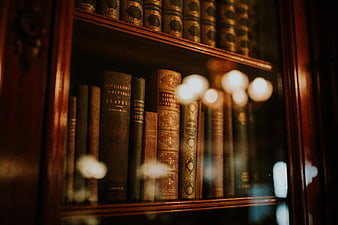 Vintage leather-bound books in a wooden library cabinet