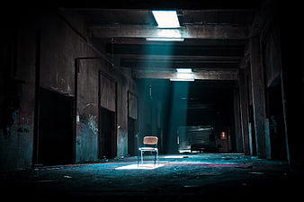 Lone Chair in Abandoned Factory with Dramatic Light Beams