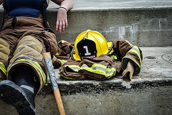 Female firefighter resting on concrete steps with gear