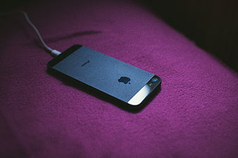 Black Smartphone Charging on Purple Fabric Background