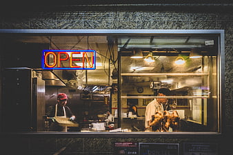Night view of restaurant kitchen with neon open sign