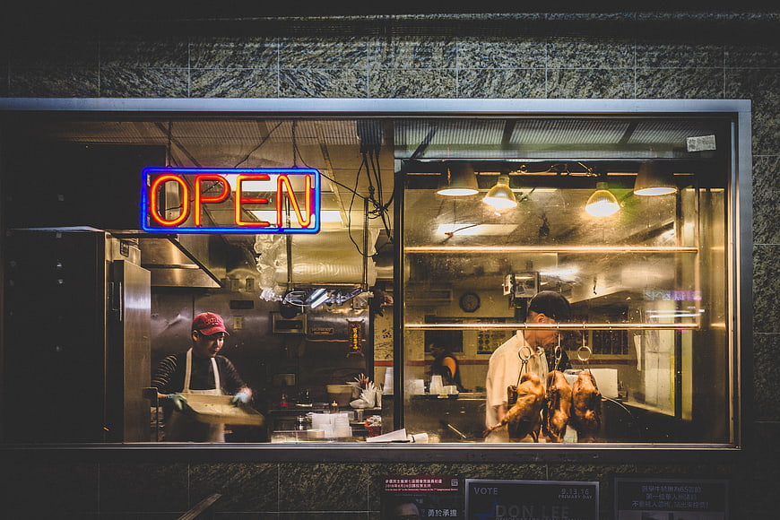 Night view of restaurant kitchen with neon open sign