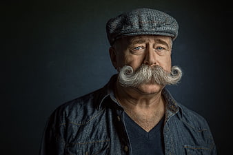 Portrait of senior man with large curled mustache and flat cap