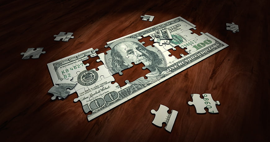 100 Dollar Bill Puzzle on Wooden Table