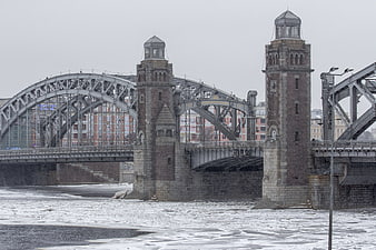 Historic Steel Arch Bridge Over Frozen River in Winter