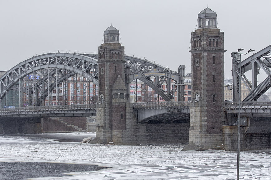 Historic Steel Arch Bridge Over Frozen River in Winter
