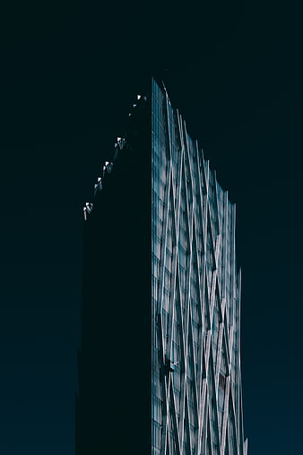 Modern Skyscraper with Geometric Facade at Night