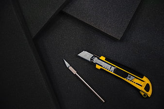 Utility knife and craft blade on black foam background