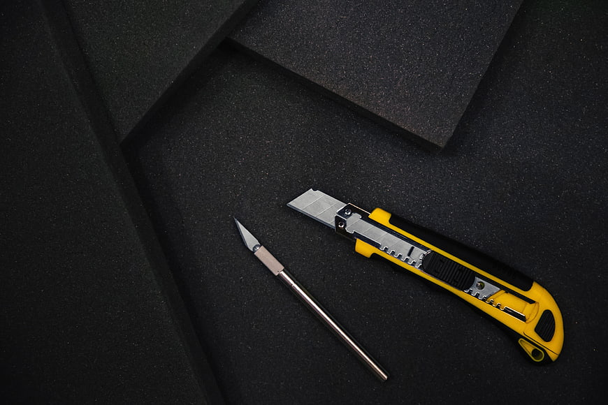 Utility knife and craft blade on black foam background