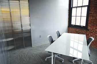 Modern office meeting room with white table and brick wall