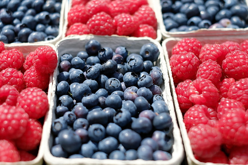 Fresh Blueberries and Raspberries in White Containers