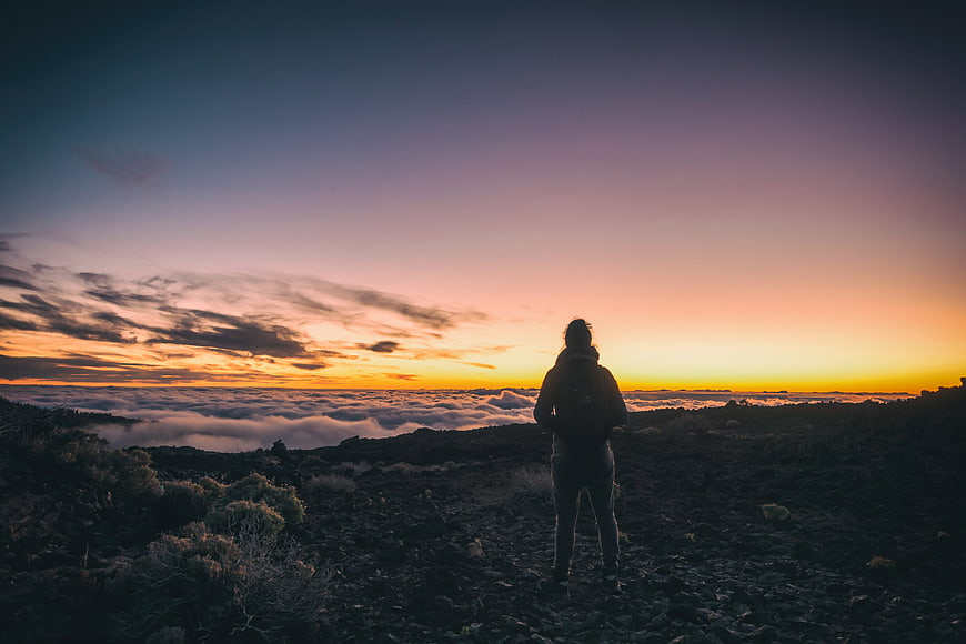 Woman Silhouette Watching Sunset Over Sea of Clouds