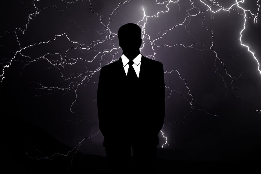 Silhouette of Businessman Against Lightning Storm Background