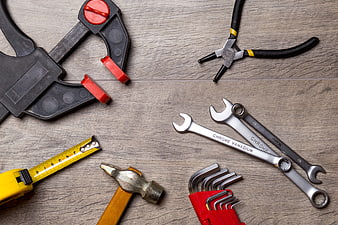 Top view of assorted hand tools on wooden background