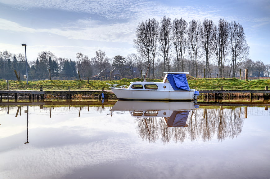 White Boat Docked at Calm Lake with Reflection