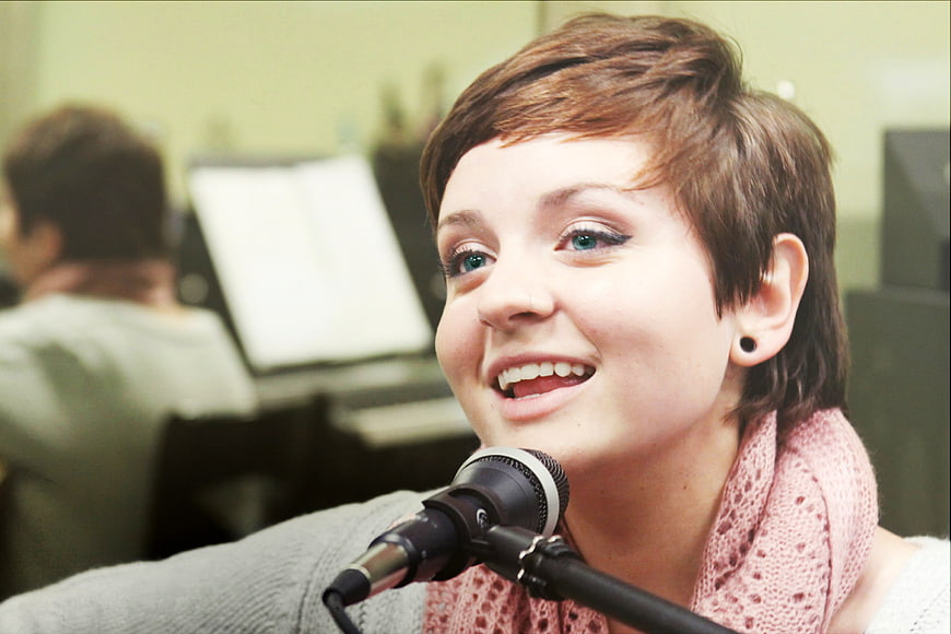 Young Woman Singing into Microphone in Studio